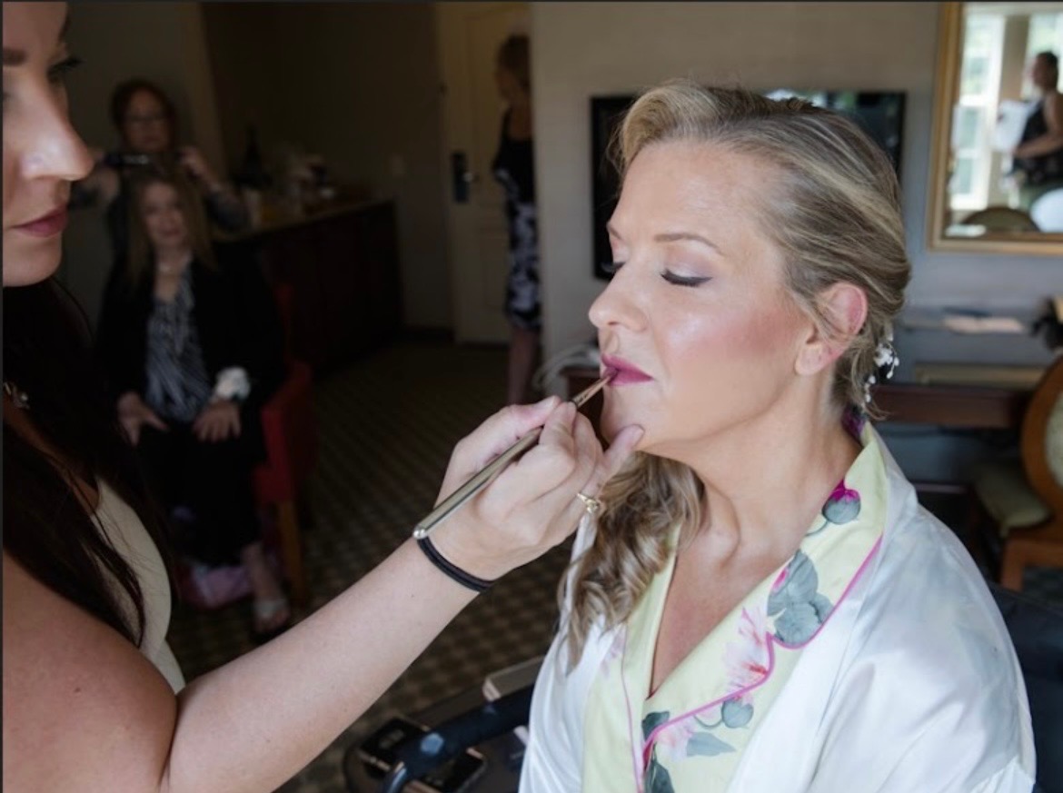 Applying lipstick to a bride getting ready